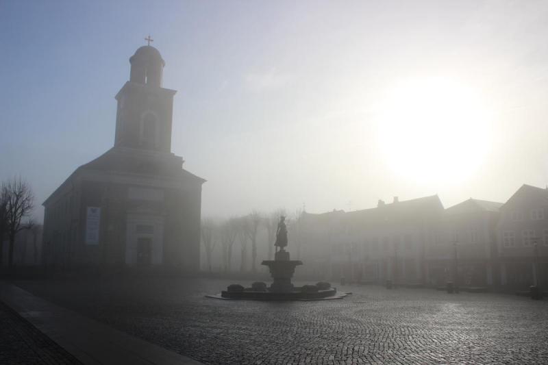 Nebel über dem Husumer Marktplatz mit Tine-Brunnen und Stadtkirche St. Marien | © Tourismus und Stadtmarketing Husum GmbH