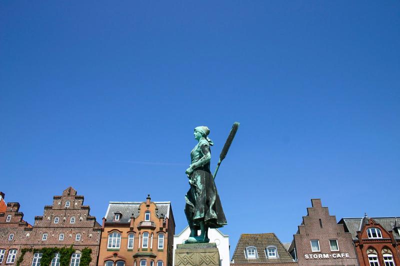 Tine-Statue am Markt vor bunter Giebelfront | © Tourismus und Stadtmarketing Husum GmbH